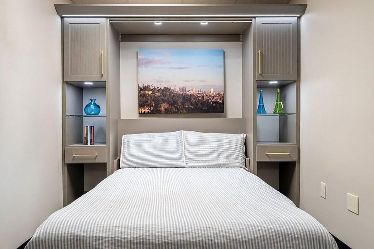 Are Murphy Beds Comfortable? An Honest Answer Queen Murphy bed open between built-in cabinets with lighted shelves