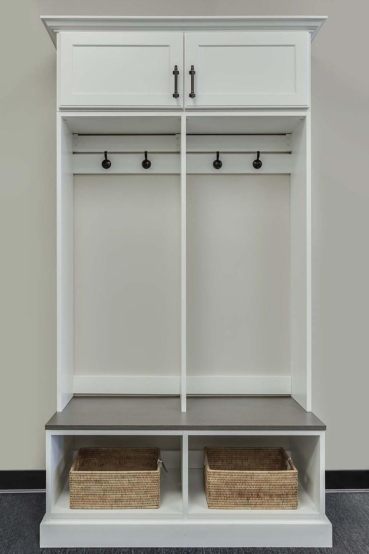 Mudroom Storage Ideas to End the Entryway Pile-Up White mudroom locker with coat hooks, a bench seat, and wicker baskets below